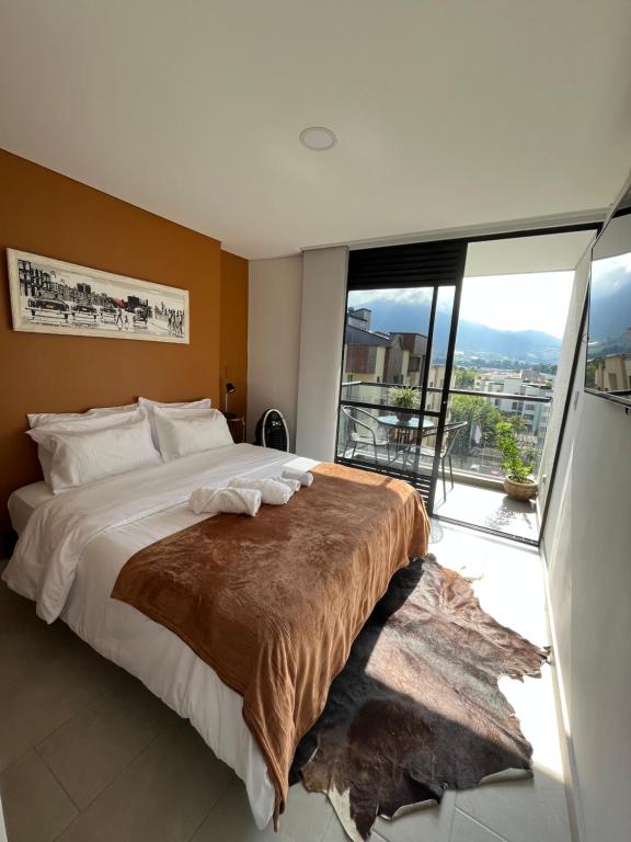 een slaapkamer met een groot bed en een groot raam bij Amplio Loft excelente ubicación norte de Armenia in Armenia