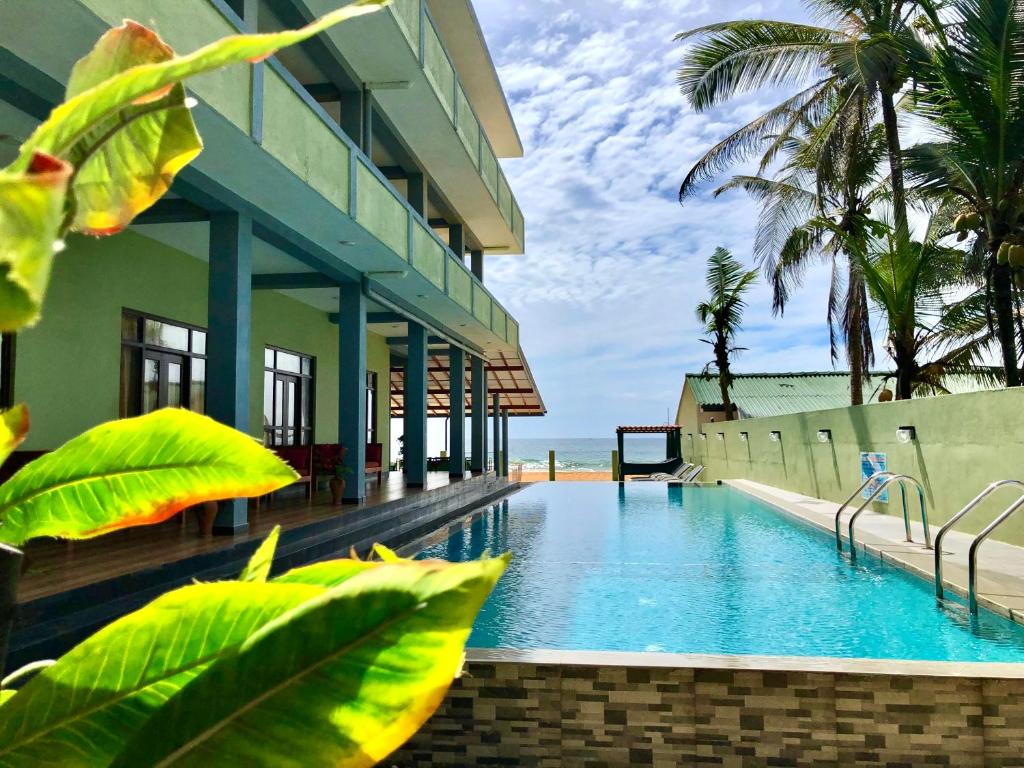 a hotel with a swimming pool next to a building at Serenade Beach Hotel in Hikkaduwa