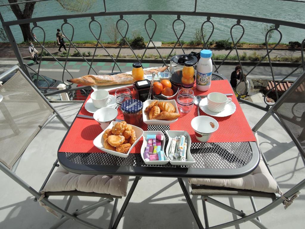 ル・ペルー・シュル・マルヌにあるLES PINGOUINS DE LA MARNEのバルコニーにテーブルと朝食用の食材