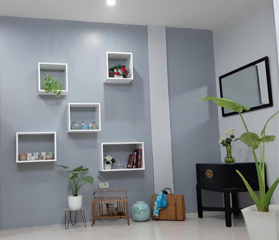 a room with a blue wall with shelves and a plant at Casa Erelle -1 Bedroom guest house w/ modern kubo in Antipolo