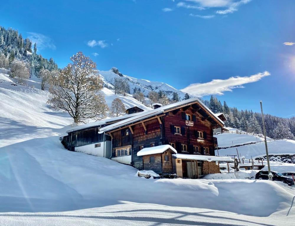 a log cabin in the snow with snow covered at Berglodge Ascharina in Sankt Antönien