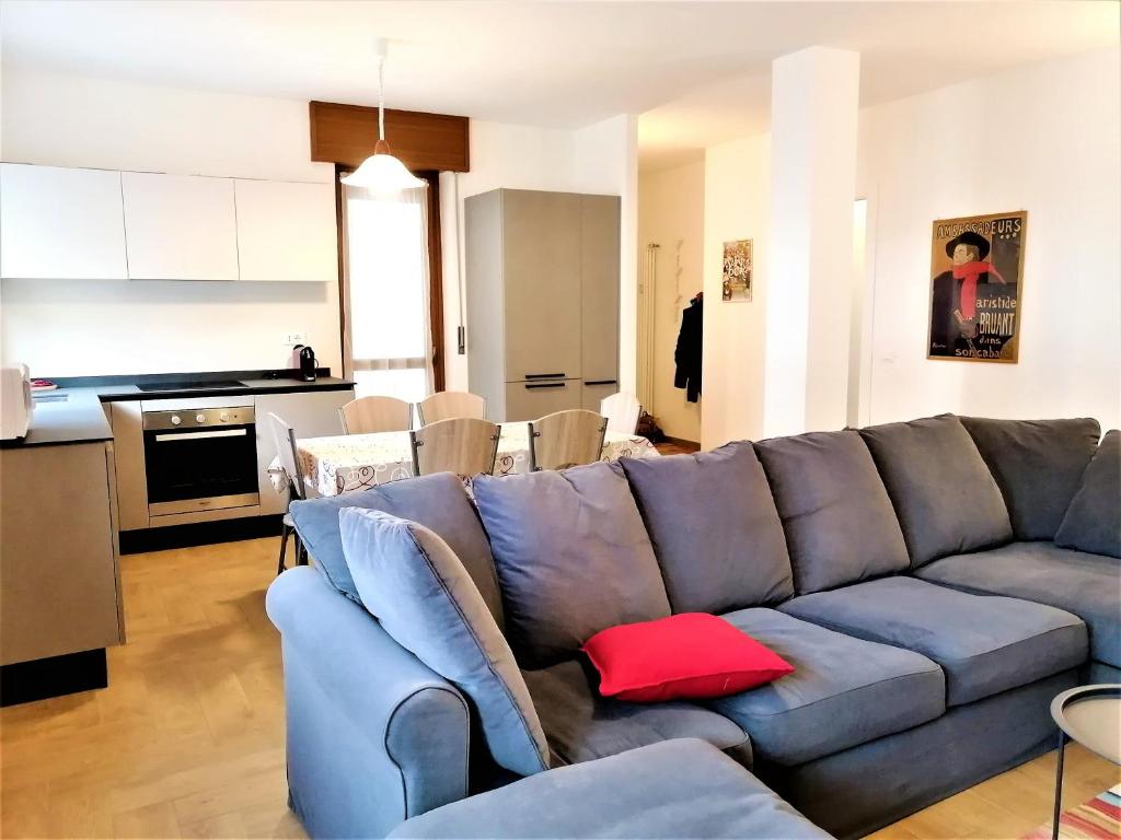 een woonkamer met een blauwe bank en een rood kussen bij Appartamento con 3 camere in centro Aosta CIR-AOSTA-0325 in Aosta