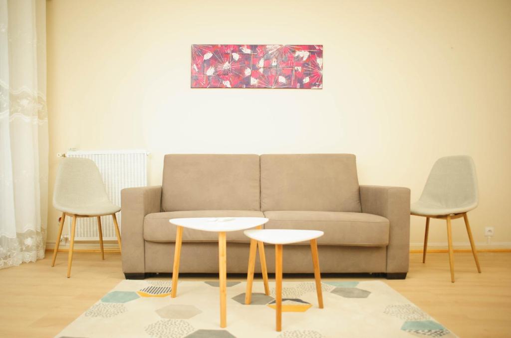 a living room with a couch and two tables at COSY HOUSE Créteil 3 pièces in Créteil