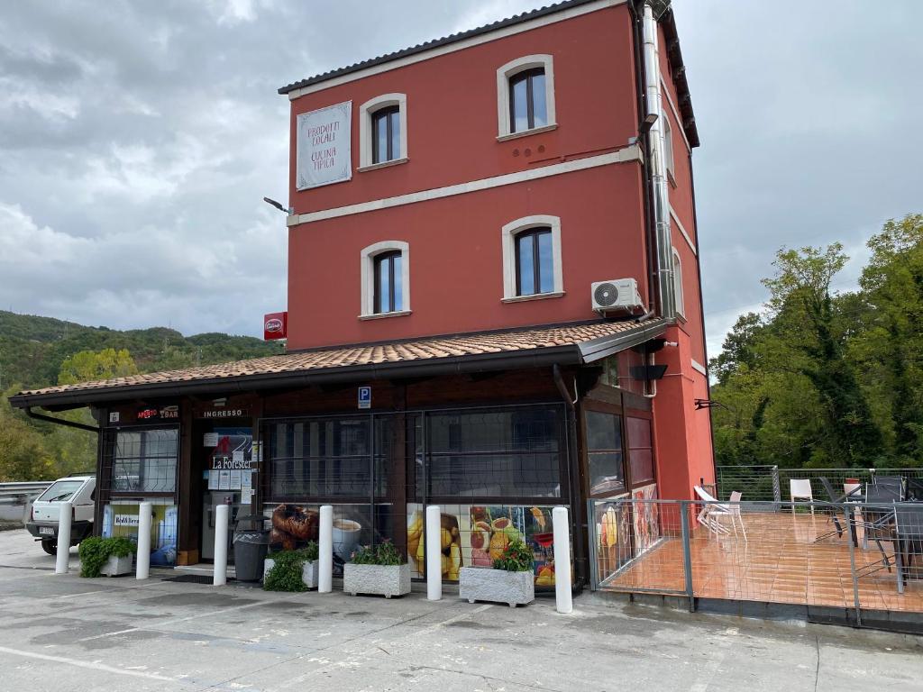 a red building with a store in a parking lot at La Foresteria in Vacchereccia