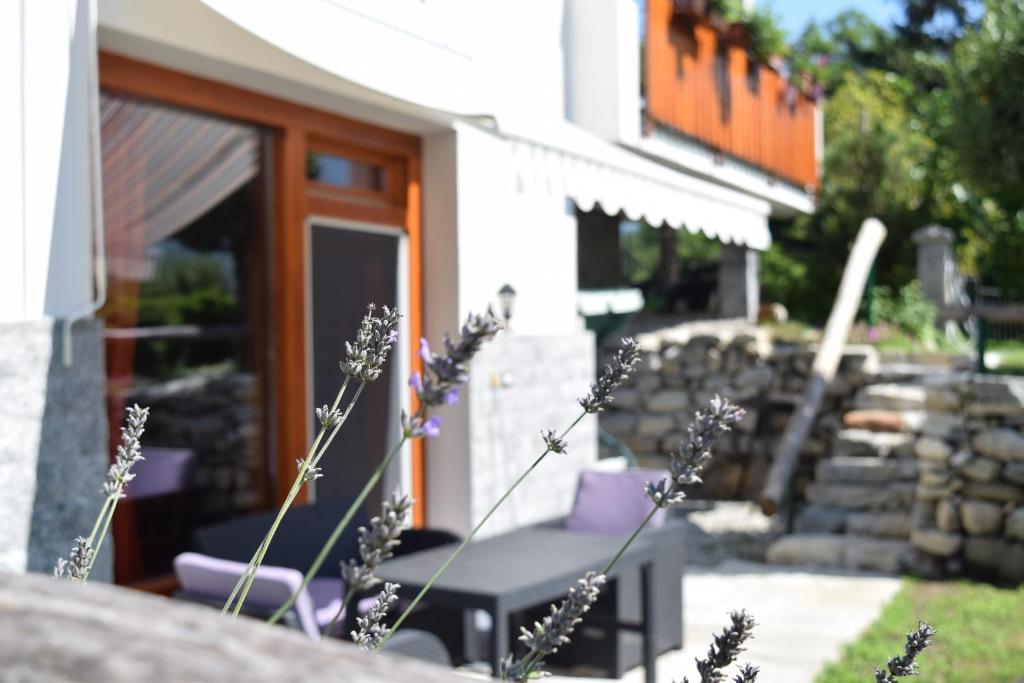 un patio con mesa y sillas frente a un edificio en Prato del bue en San Cassiano