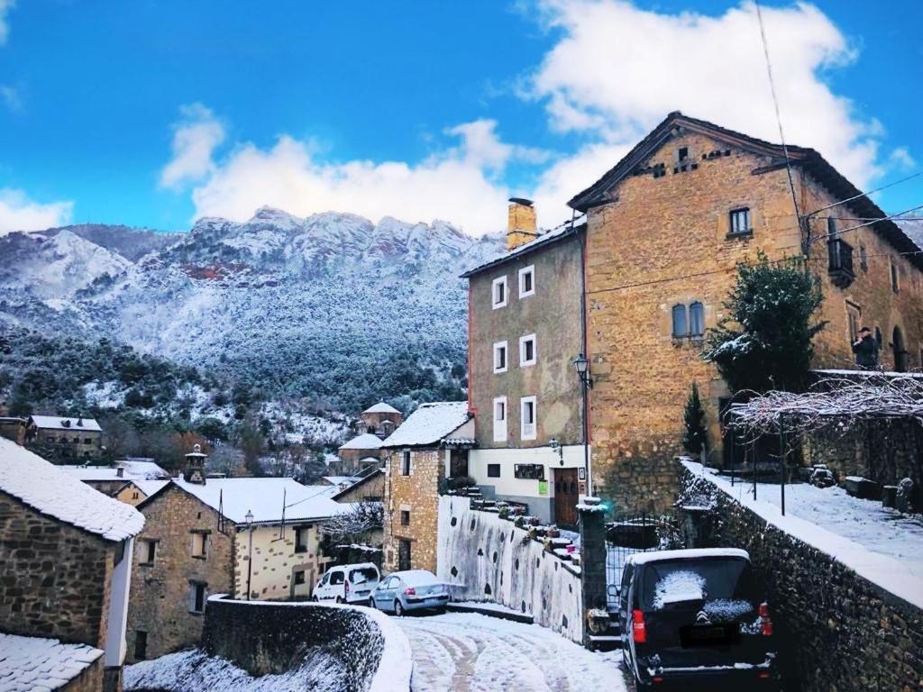 uma cidade na neve com montanhas ao fundo em CASA SENERA em Santa Cruz de la Serós