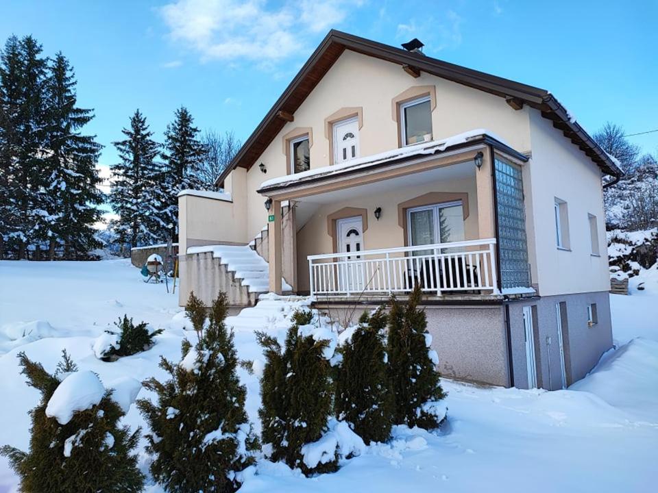 a house in the snow with trees at Cozy Holiday Home in Bjelašnica