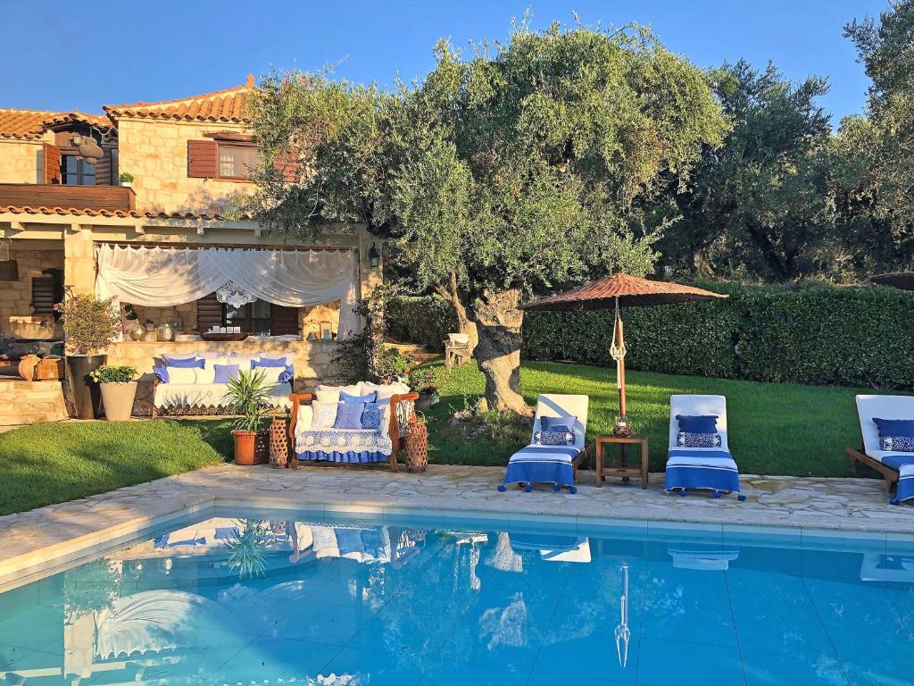 uma piscina com duas cadeiras e um guarda-sol em Lalla Luxury Villa em Lithakia