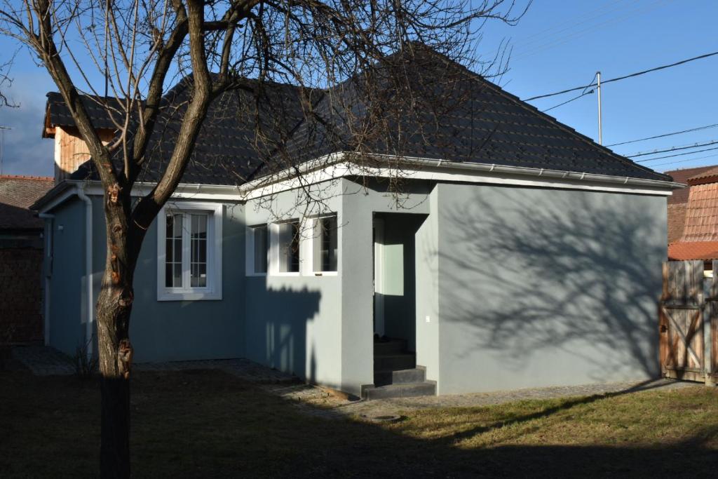 ein kleines weißes Haus mit schwarzem Dach in der Unterkunft FLH - Grandparent's House- A small beautiful house in Sibiu