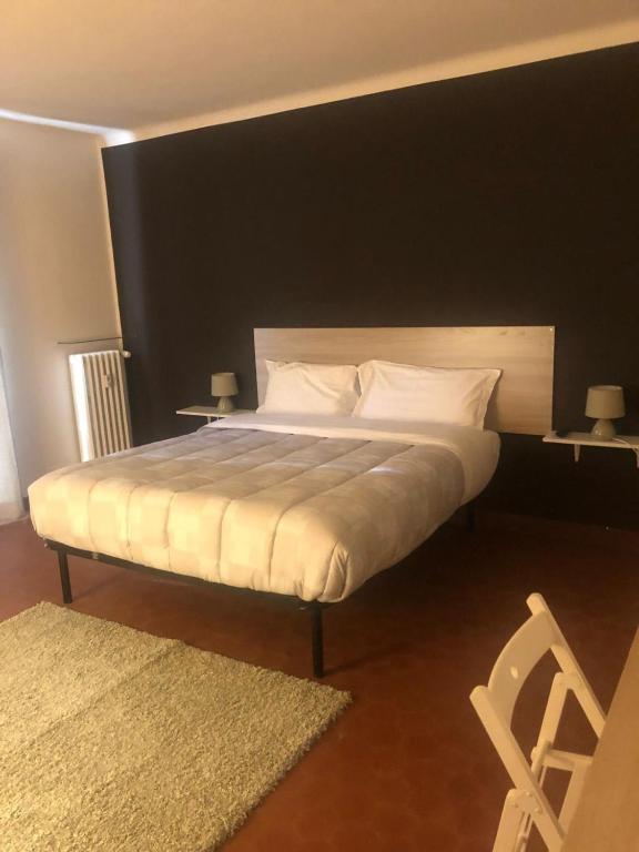 a bedroom with a large bed with a black wall at MyRoom sui Portici in Bologna