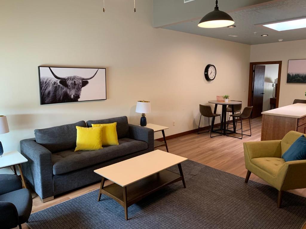 a living room with a couch and a cow on the wall at Stylish ground level apartment close to everything in Rapid City