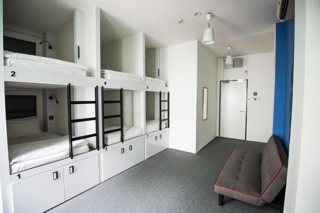 a room with two bunk beds and a couch at Wink at Mosque Street in Singapore