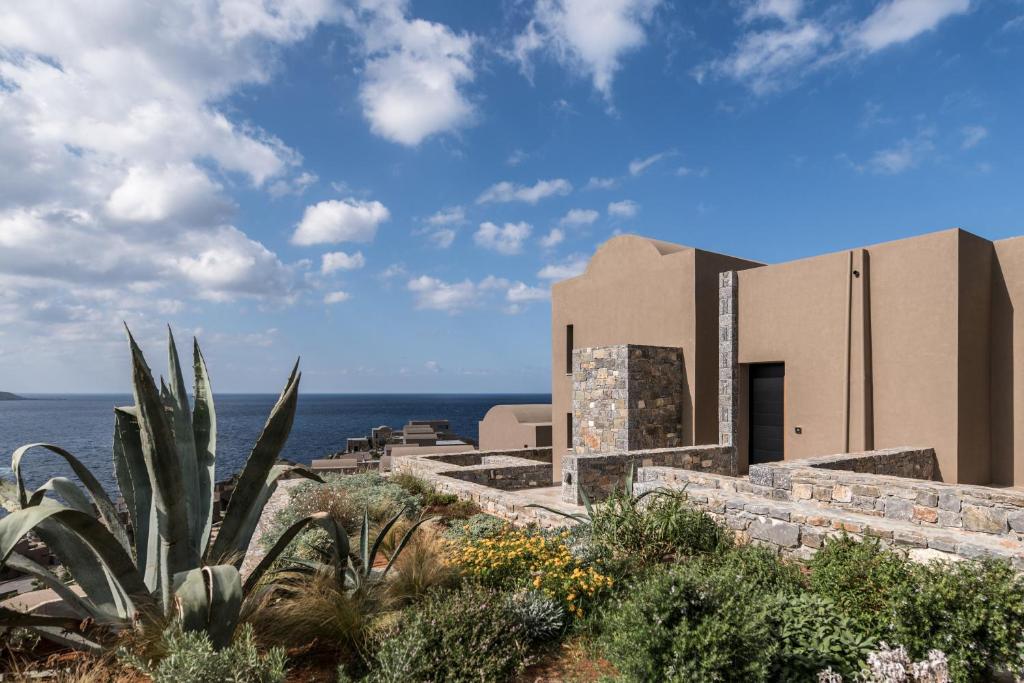 a building with the ocean in the background at Acro Suites - A Wellbeing Resort in Agia Pelagia