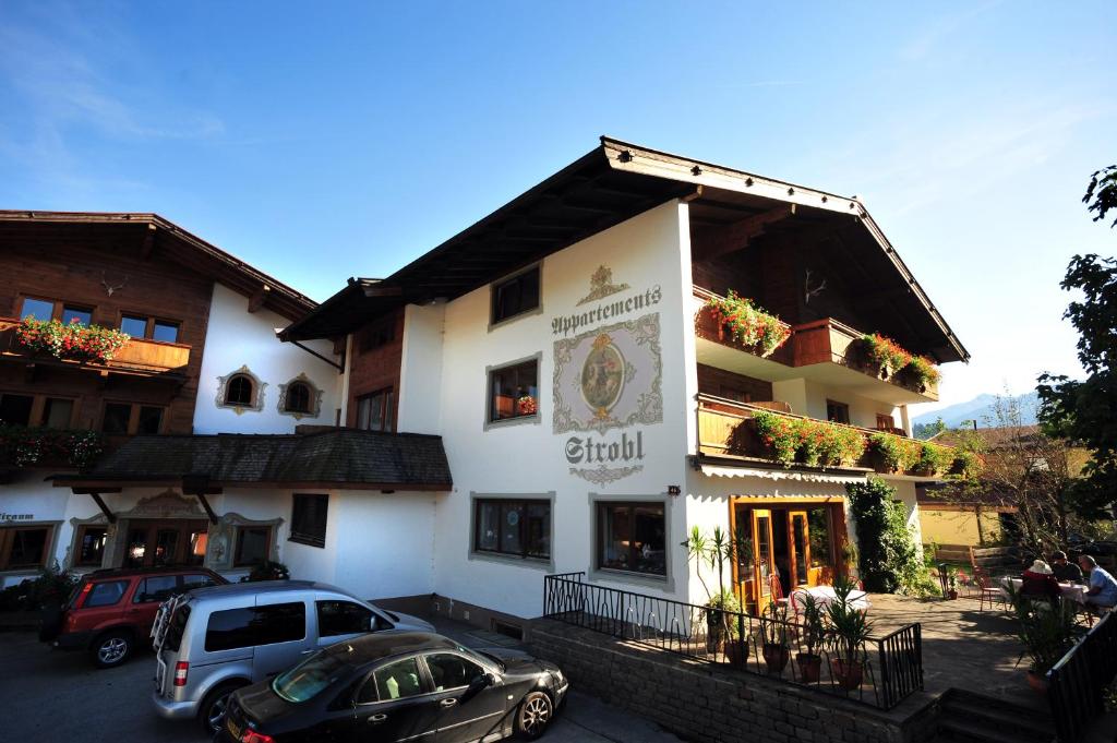 a building with cars parked in front of it at Appartements Strobl in Hopfgarten im Brixental