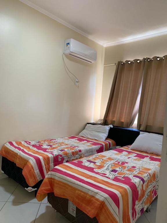 1 dormitorio con 2 camas y aire acondicionado en Edifício Bernardo, en Bombinhas