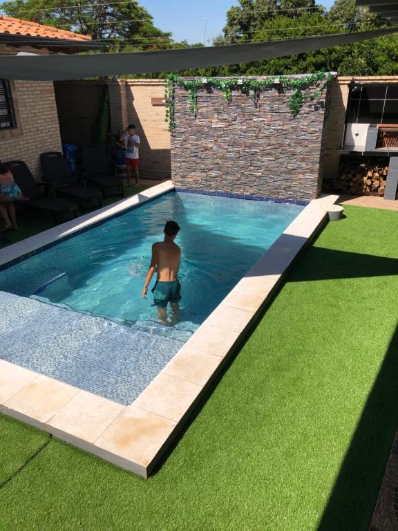 a man is standing in a swimming pool at Alquiler San Bernardino Altos Loma grande in Loma Grande