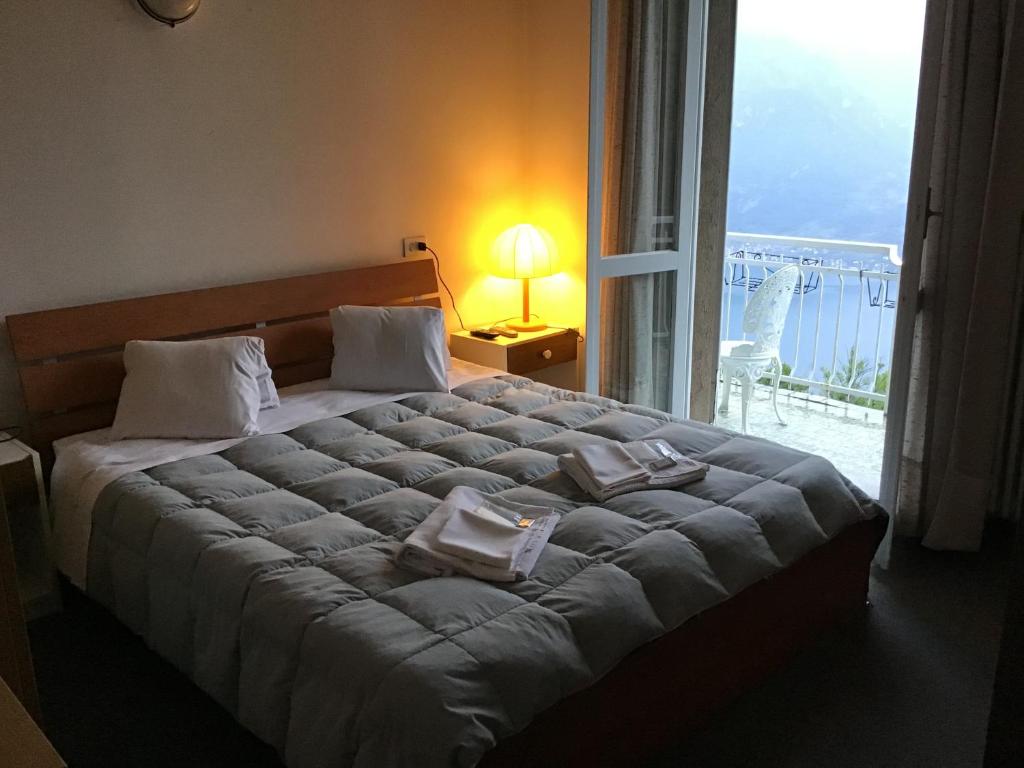 a bedroom with a large bed with a large window at LOCANDA MIRABEAU in Bellagio