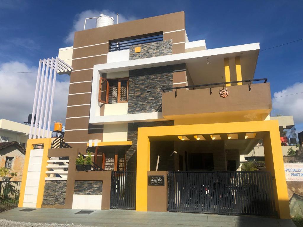 a house with a yellow and white at Sapthagiri Nest in Chikmagalūr