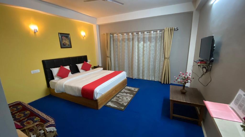 ein Schlafzimmer mit einem Bett und einem TV in der Unterkunft Hidden Gem Residency in Kalimpong