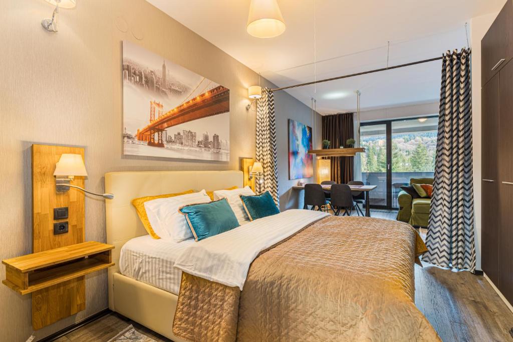 a bedroom with a bed and a living room at MAIO Studio Silver Mountain Poiana Brasov in Poiana Brasov