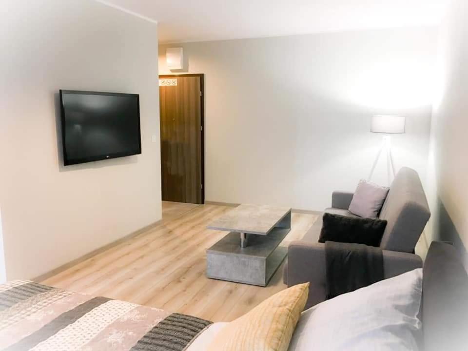 uma sala de estar com um sofá e uma mesa em Apartament Konin Prestige em Konin