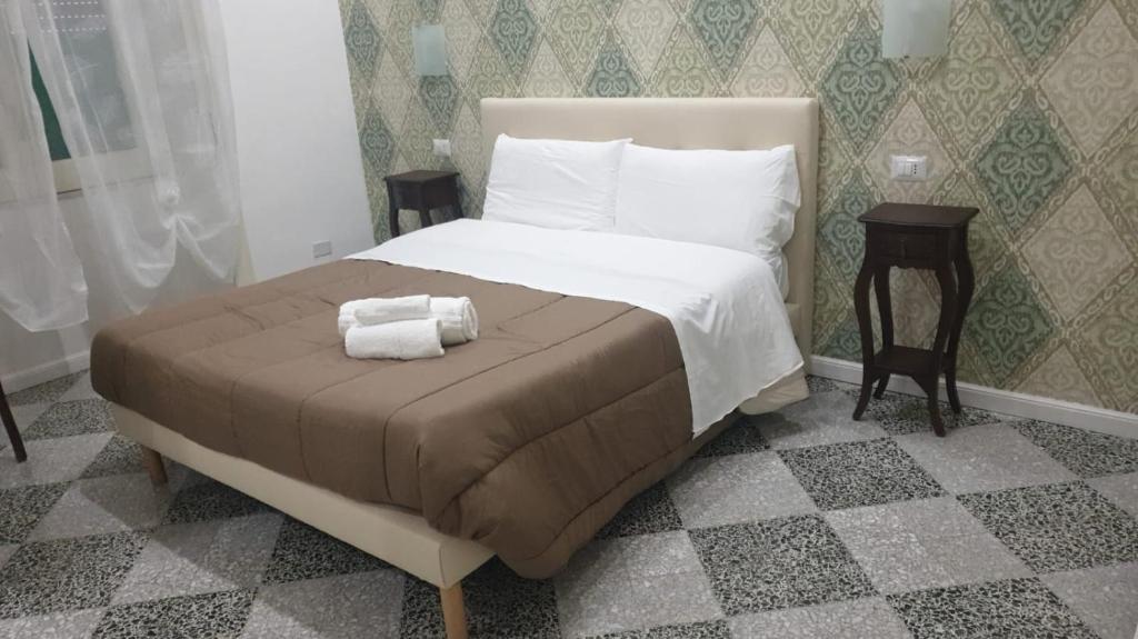 a bedroom with a bed with two towels on it at B&B By the Station in Battipaglia