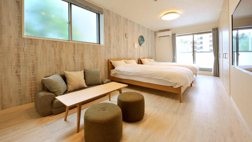 1 dormitorio con cama, sofá y mesa en RakutenSTAY x Shamaison Osaka Dekijima - 104, en Osaka