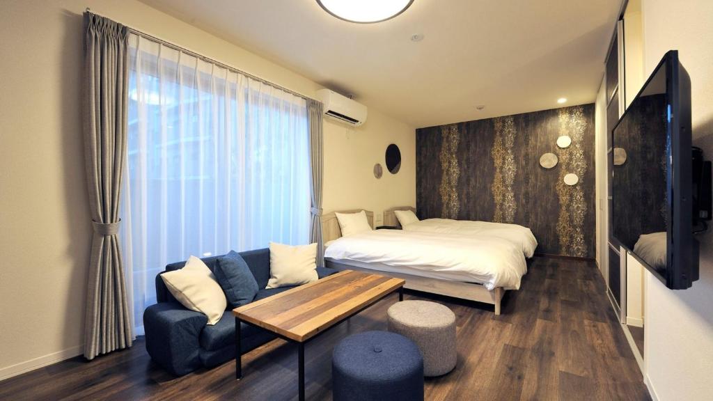 1 dormitorio con cama, sofá y mesa en RakutenSTAY x Shamaison Osaka Dekijima - 201 en Osaka