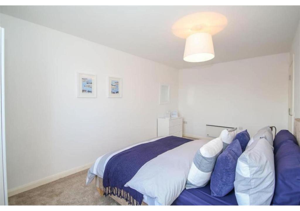 a bedroom with a bed with blue and white pillows at 3 Bedroom Beautiful Apartment in Manchester
