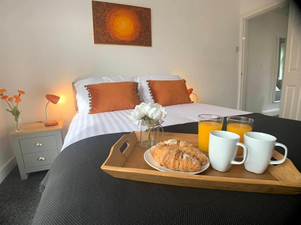 a tray with a plate of croissants and drinks on a bed at CrowTrees in Brighouse