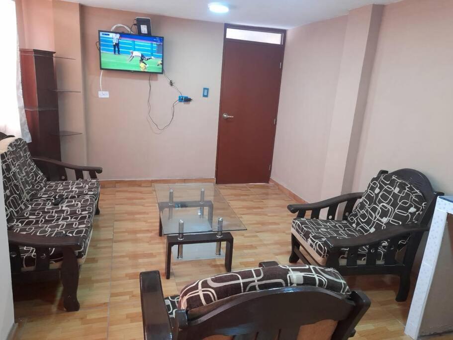 sala de estar con 2 sillas, mesa y TV en Kely3 Cuarto Piso, en Lima