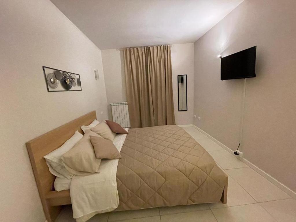 a bedroom with a large bed and a flat screen tv at 100 PASSI in Palermo