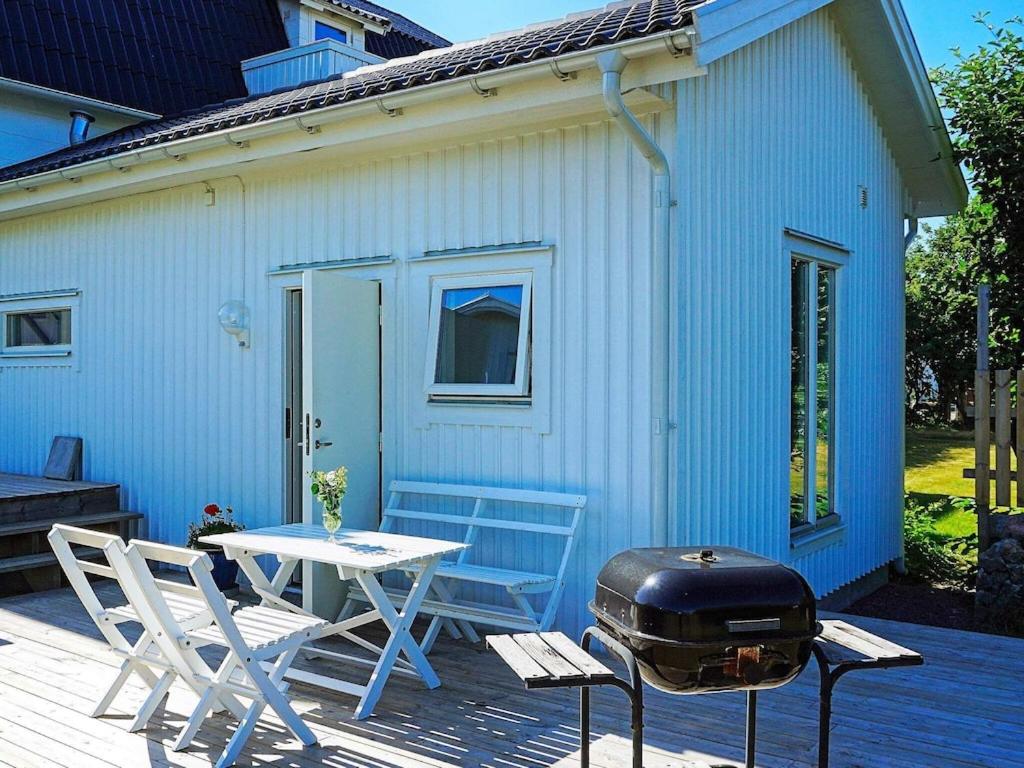 - un barbecue, une table et des chaises sur la terrasse dans l'établissement 4 person holiday home in ker, à Öckerö
