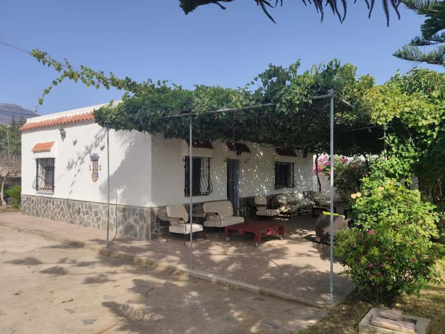 een wit huis met een tuin en een patio bij Encantadora casa rural con gran porche in San Roque