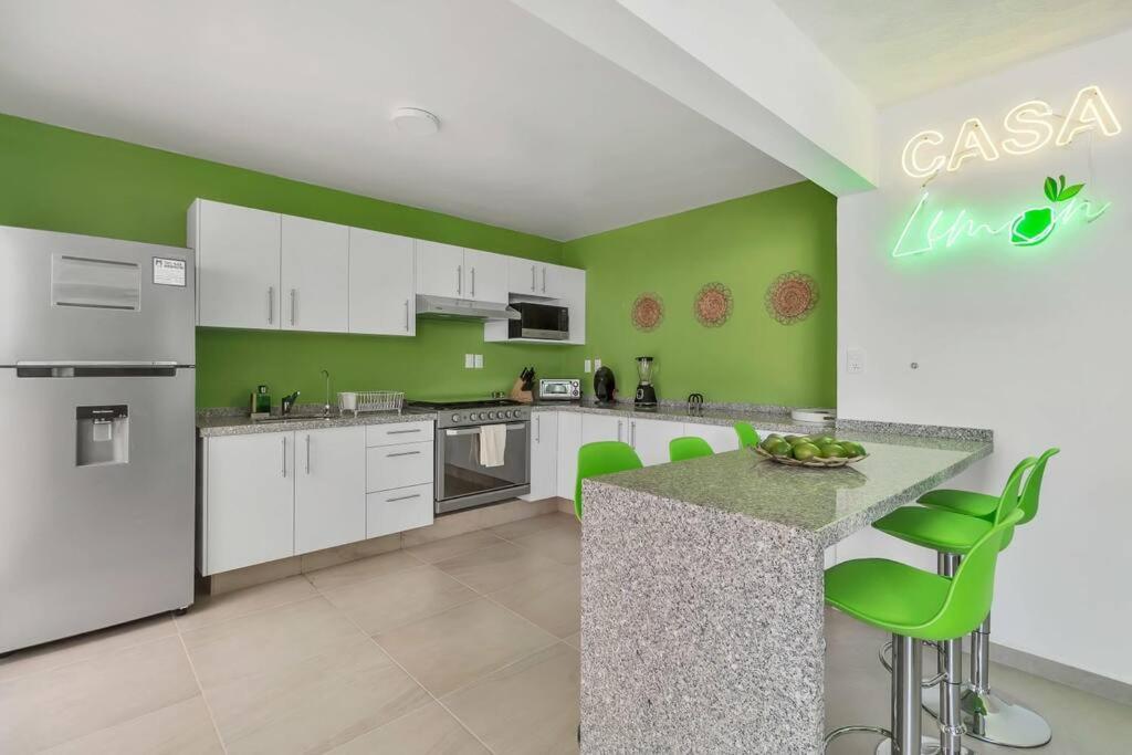 eine Küche mit weißen Geräten und grünen Wänden in der Unterkunft +MS +Casa Limón +16 Pax +Wifi 150Mb in Querétaro