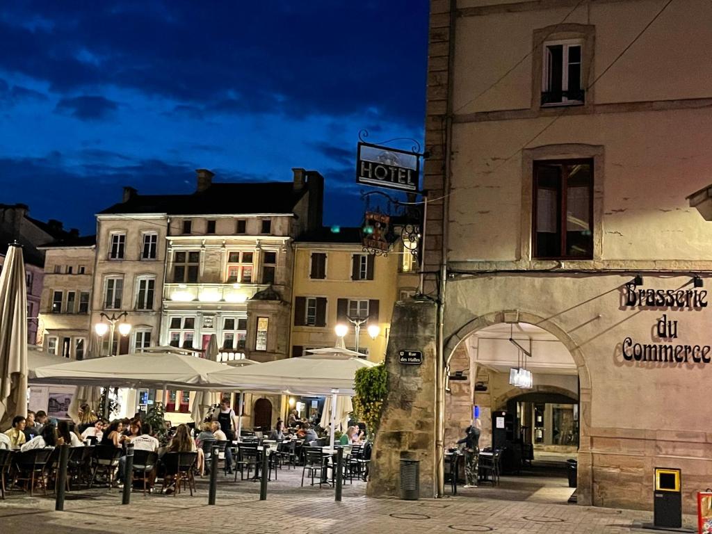 a group of people sitting at tables outside a building at Épinal : superbe appartement en plein centre ville in Épinal