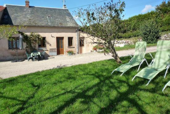 zwei grüne Stühle im Gras vor einem Haus in der Unterkunft Gîte du Morvan in Saint-Germain-des-Champs