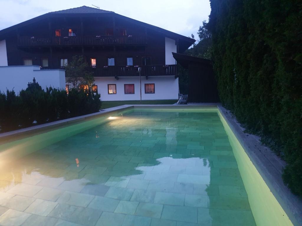 a swimming pool in front of a house at night at Residence Baumgartner in Völs am Schlern