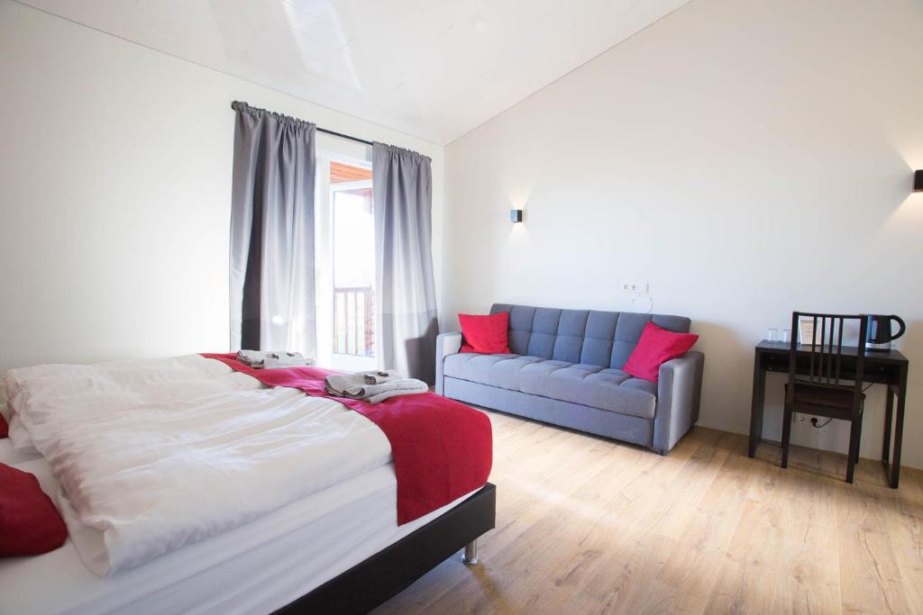 a bedroom with a bed and a blue couch at Guesthouse Fludir in Fludir