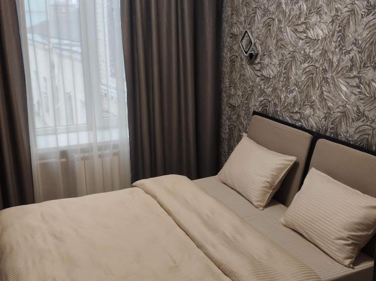 a bedroom with a bed with two pillows and a window at STAR CITY Hostel in Kyiv