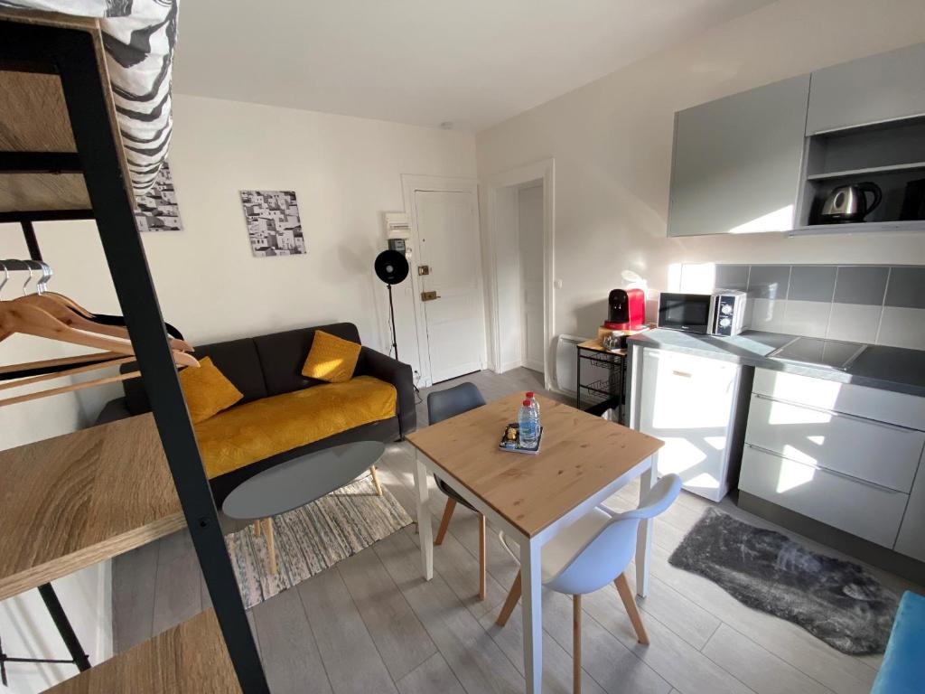 a small living room with a couch and a table at ENGHIEN-LES-BAINS : studio au coeur du centre ville in Enghien-les-Bains