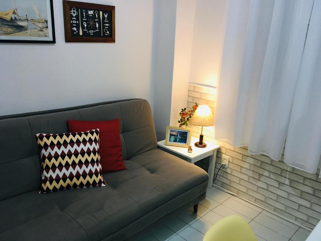 Kitnet aconchegante Beira Mar. في سانتوس: غرفة معيشة مع أريكة وطاولة مع الكمبيوتر المحمول