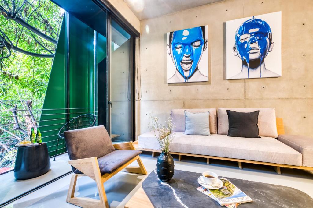 
a living room filled with furniture and a painting on the wall at ULIV Apartments - Roma Norte in Mexico City
