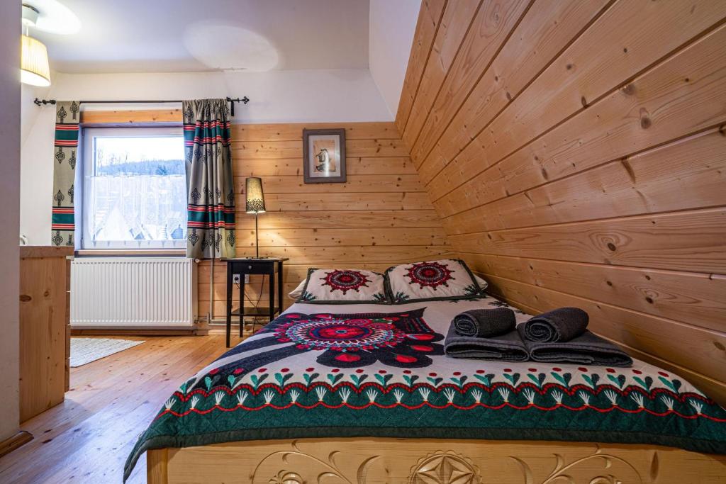 1 dormitorio con 1 cama en una habitación de madera en Willa Cicha Woda Centrum, en Zakopane