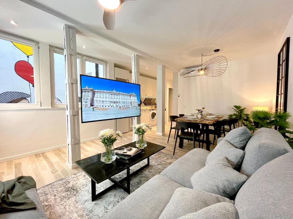 een woonkamer met een grijze bank en een tv bij BNBHolder PUERTA DE ALCALA es MIA in Madrid