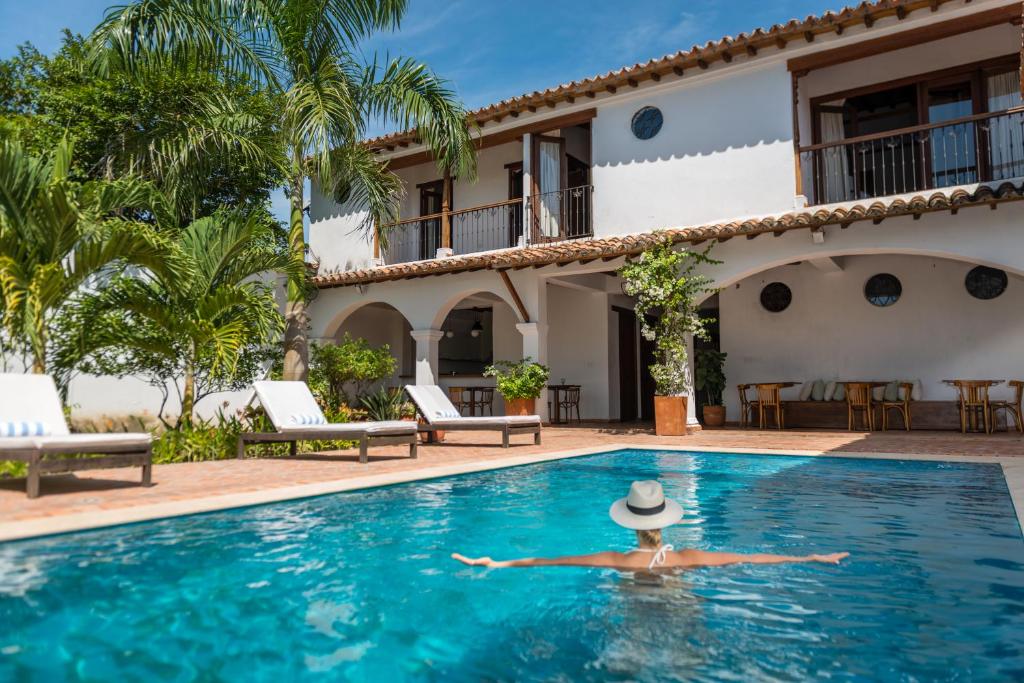 un hombre con sombrero tirado en la piscina de una villa en San Rafael, en Mompox