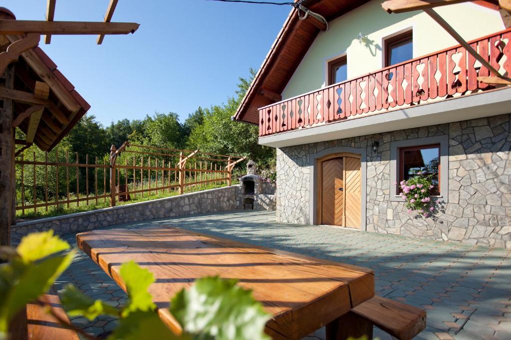 a house with a balcony and a wooden walkway at Vineyard Cottage Lustek in Novo Mesto