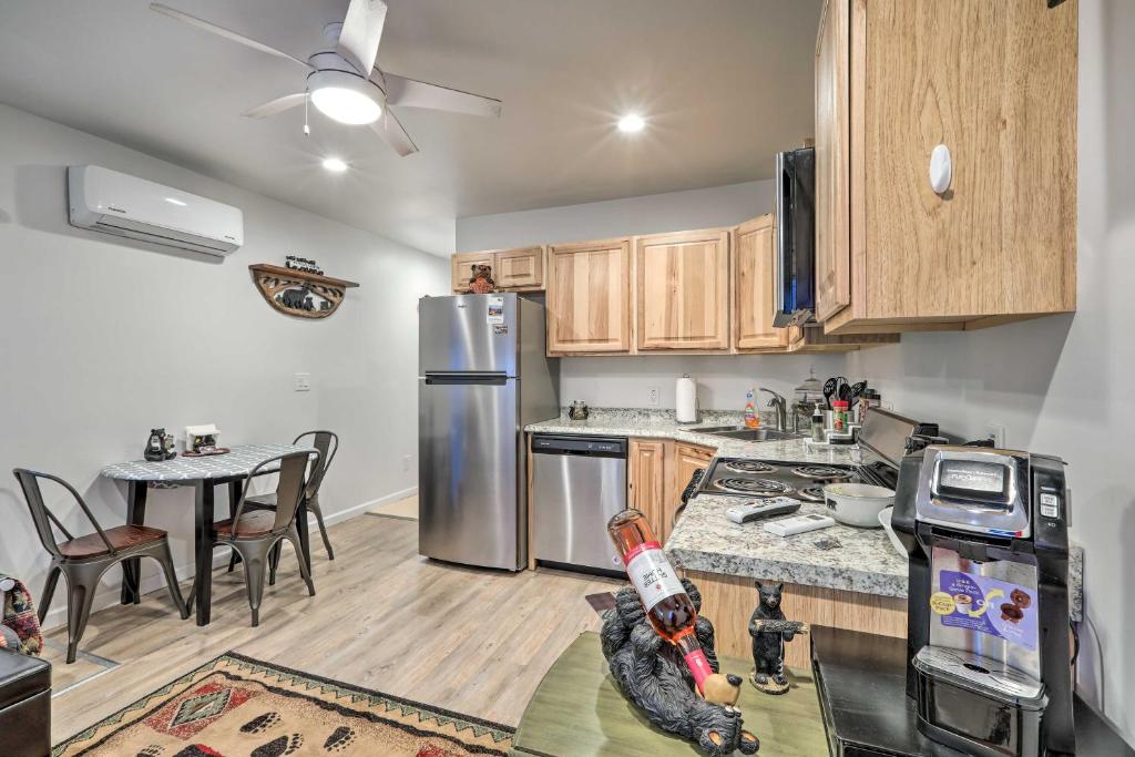 a kitchen with wooden cabinets and a stainless steel refrigerator at Cozy Northern Arizona Studio in Downtown Williams! in Williams