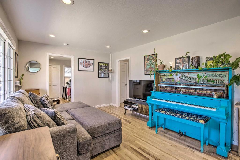 a living room with a couch and a piano at Comfy Aurora Hideout with Yard and Covered Patio! in Aurora