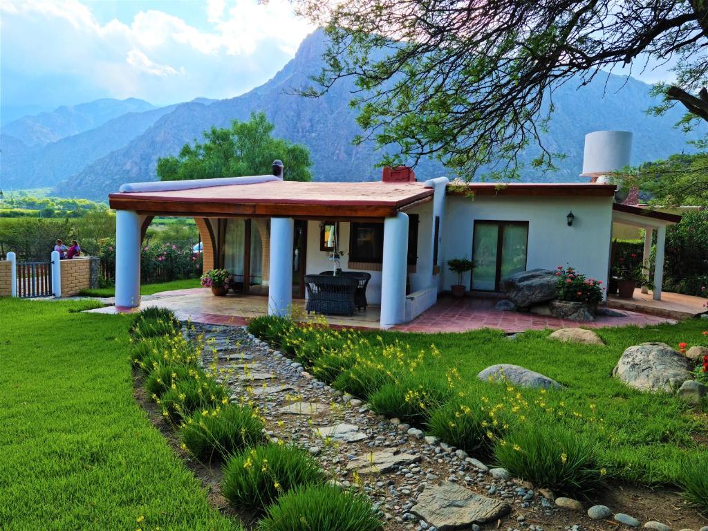 ein kleines Haus mit einer Veranda mit Bergen im Hintergrund in der Unterkunft Casa Santa Teresita in Cafayate